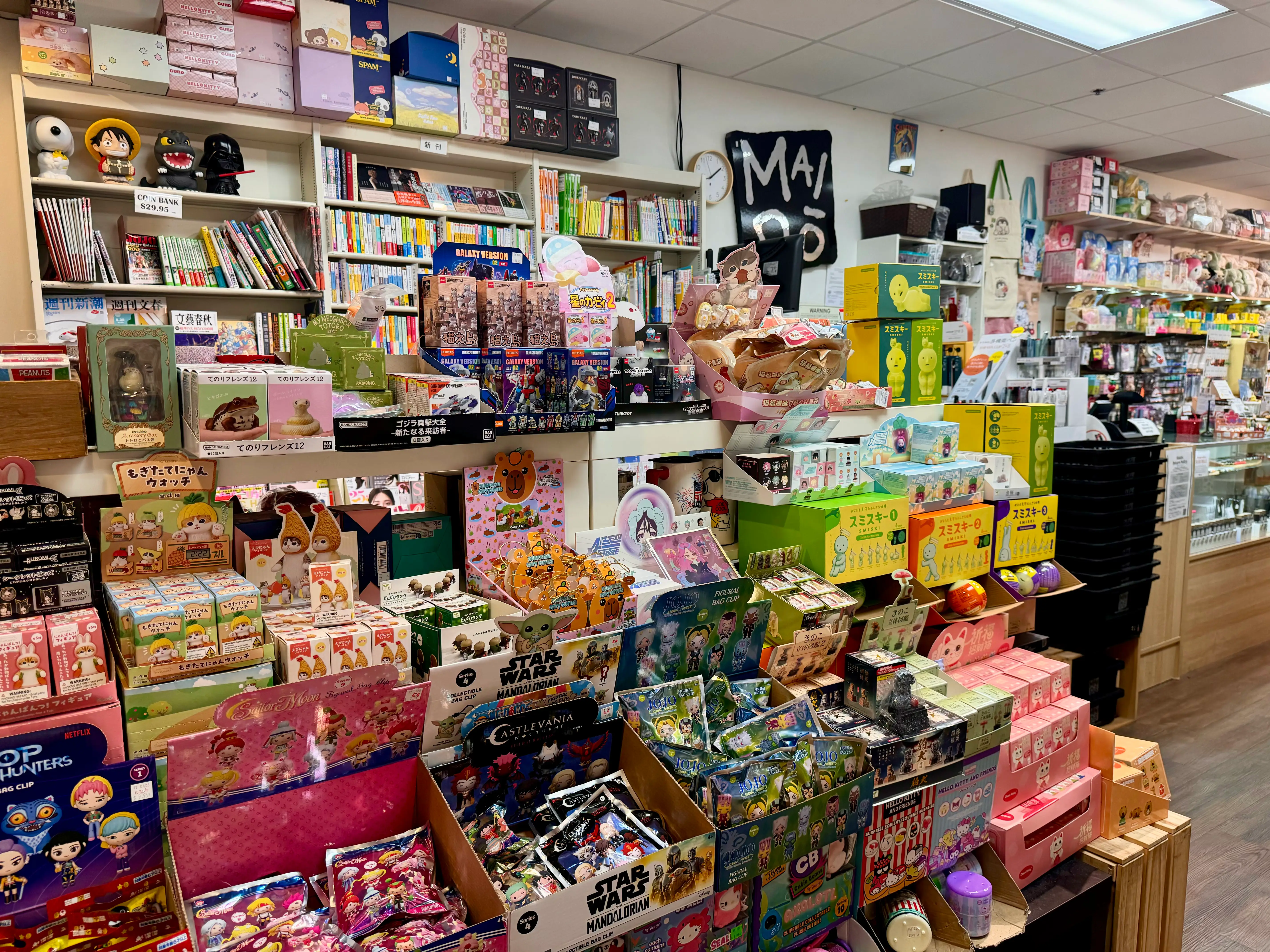A colorful store interior filled with Japanese toys, figurines, stationery, candy, and books on shelves and displays, creating a busy and vibrant atmosphere.