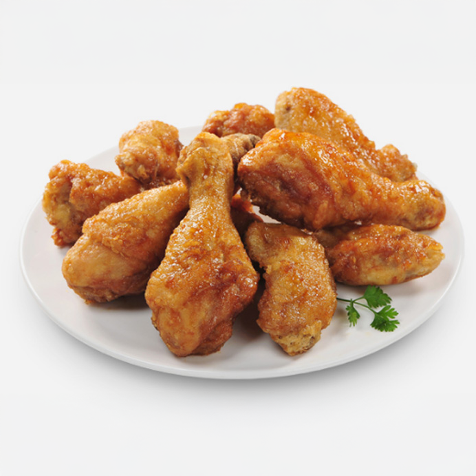 A white plate filled with several golden-brown fried chicken drumsticks, garnished with a small sprig of parsley on the side, evokes comfort food perfection—just like you'd find at Mesa Verde in Costa Mesa. The background is plain white.