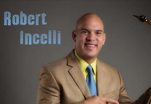 A smiling man in a tan suit, yellow shirt, and blue tie poses holding a saxophone. The name Robert Incelli appears in blue text on the left side of the image.