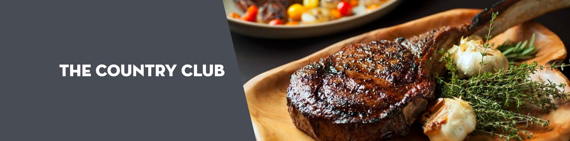Grilled tomahawk steak with herbs and roasted garlic on a wooden platter, next to text that reads “The Country Club” on a gray background.