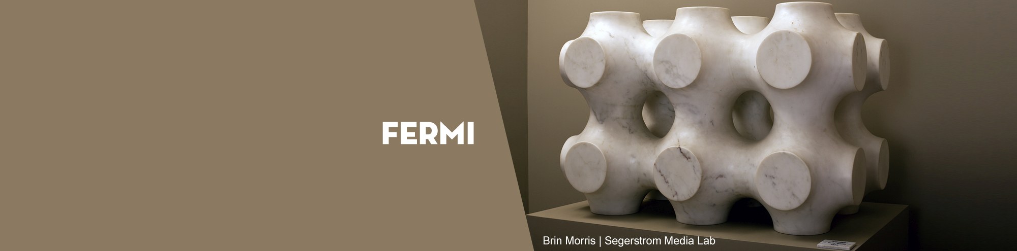 A geometric white marble fermi sculpture with circular and square cutouts sits on a pedestal in a Costa Mesa gallery. The word FERMI and a label for Brian Morris | Sagesstrom Media Lab appear on the image.
