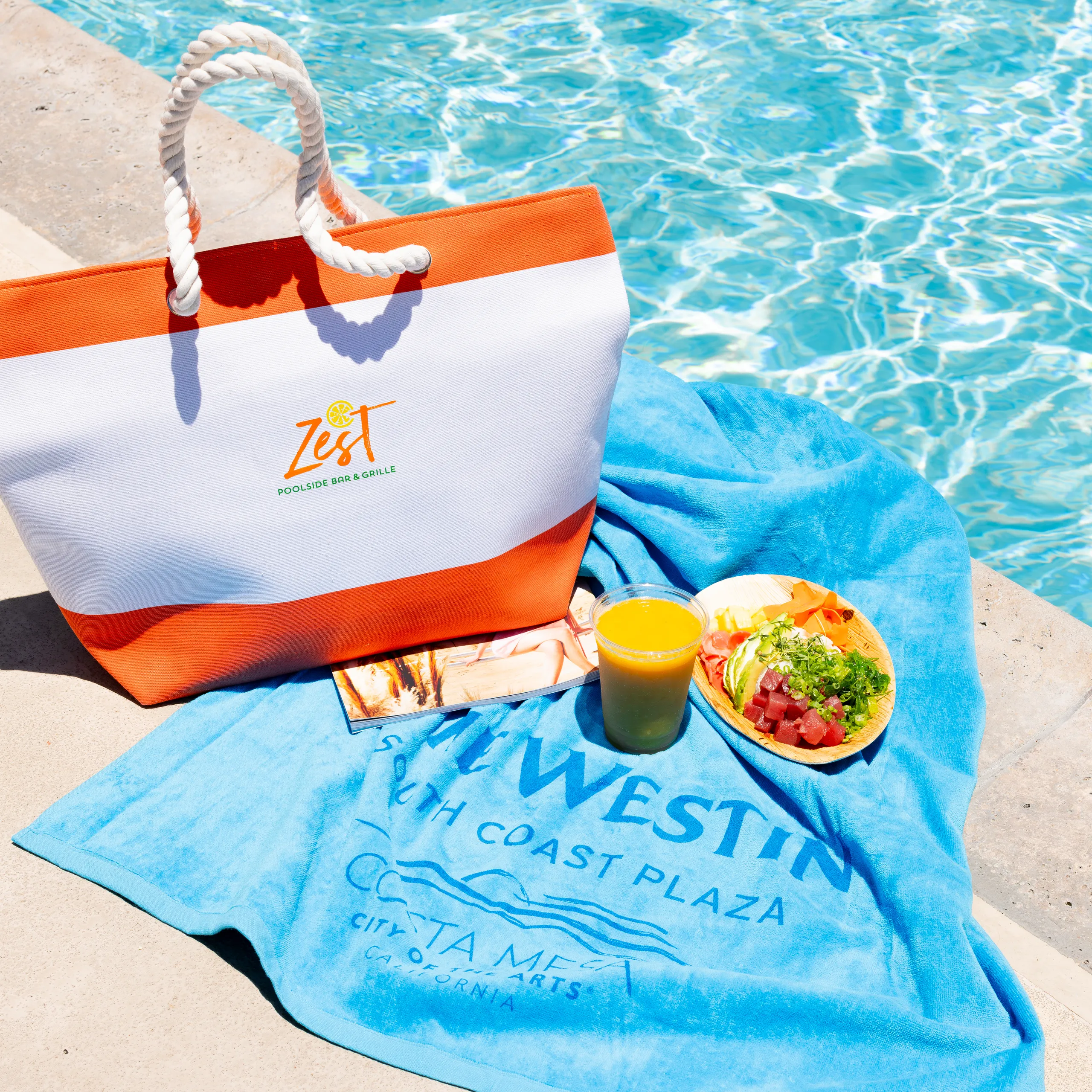 Pool towel and bag sitting poolside