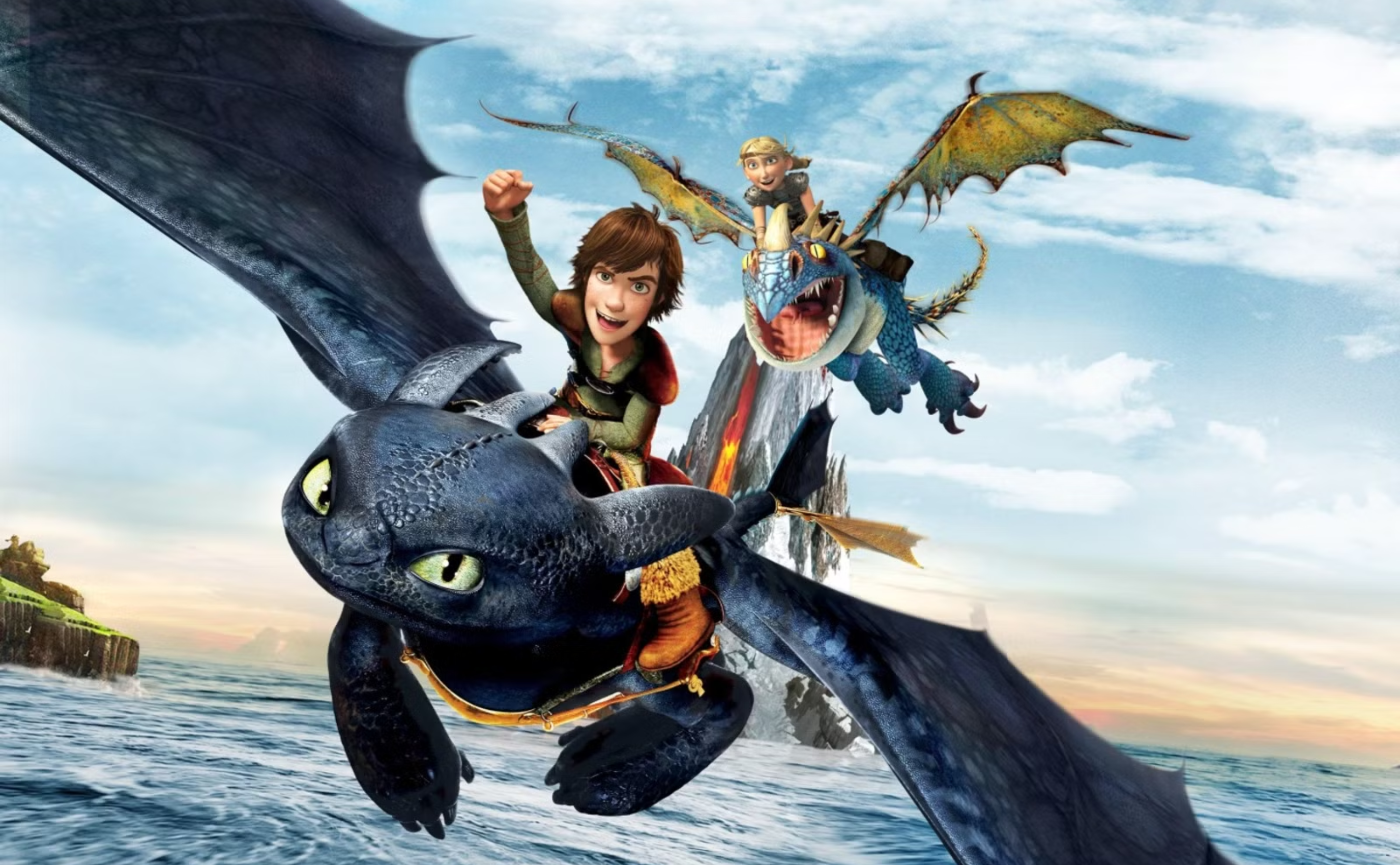 Two animated characters ride dragons over the ocean; the foreground dragon is black with green eyes, ridden by a brown-haired boy, while a blond character rides a blue and yellow dragon behind them. The sky is partly cloudy.